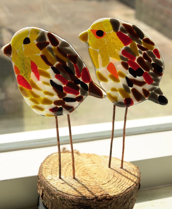 Vogeltje van glas op boomstammetje